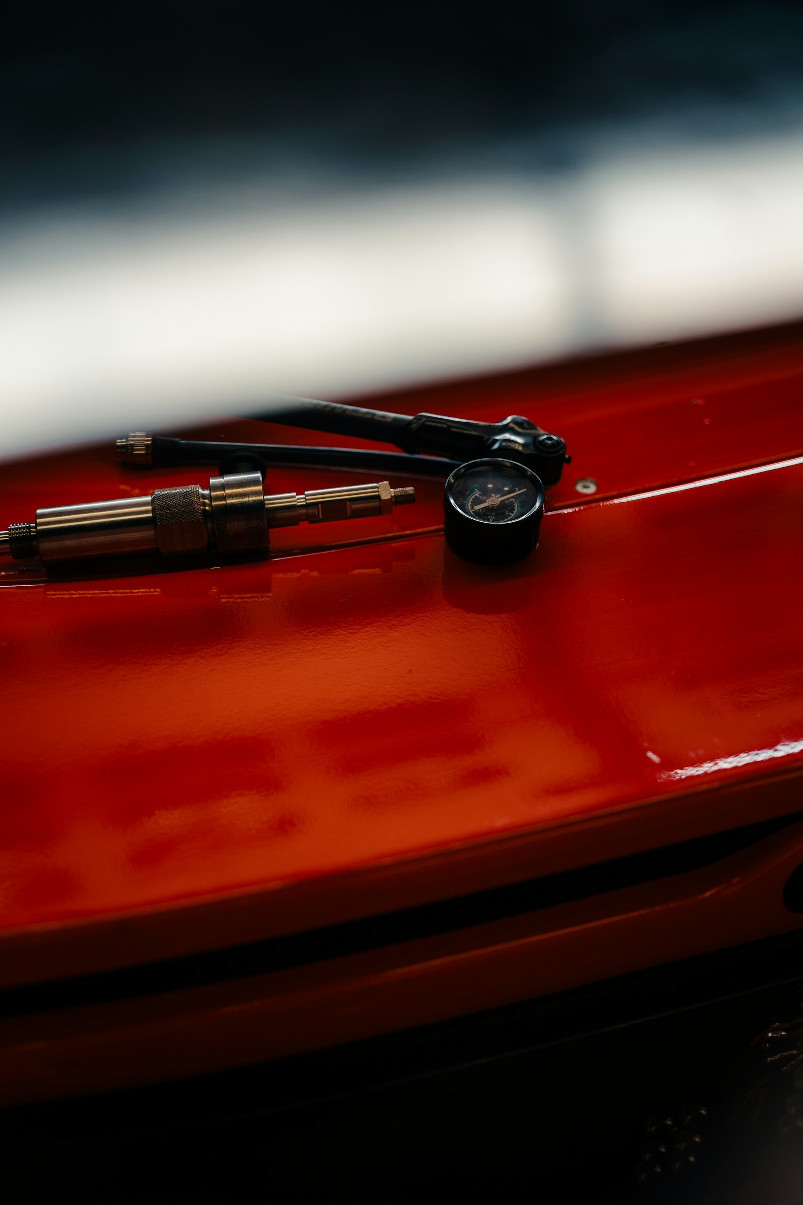 A portable tire inflator nozzle and pressure gauge